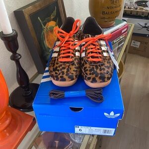 Addidas women’s textured leopard print tennis shoes with orange laces.
